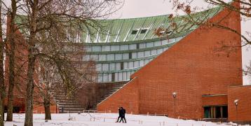 People walking in snow in front of building